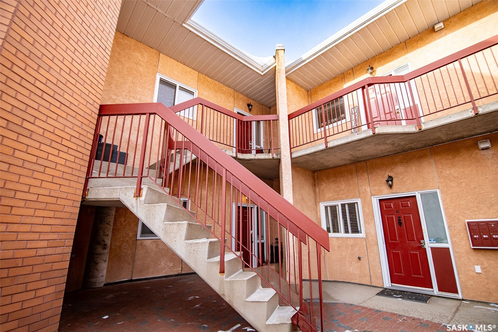 Multi-level exterior with stucco finish and brick accent