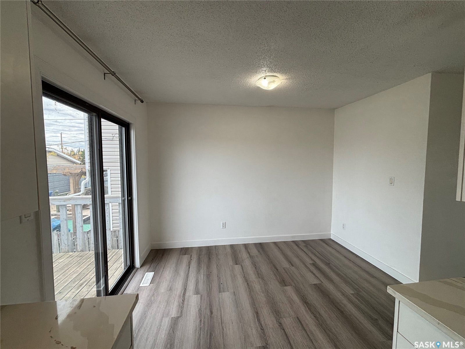 Wood-finish flooring, white walls, and a ceiling-mounted light fixture