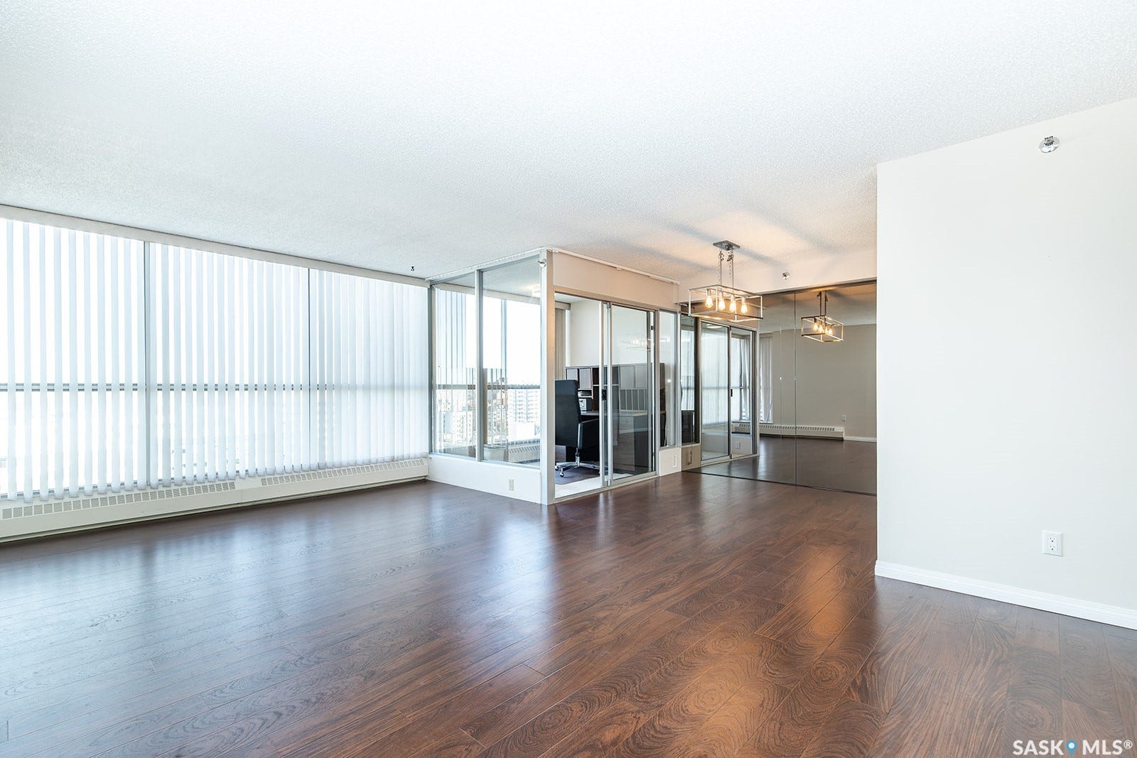 Laminate flooring, full-height windows with vertical blinds, glass-enclosed office space that can be removed if desired