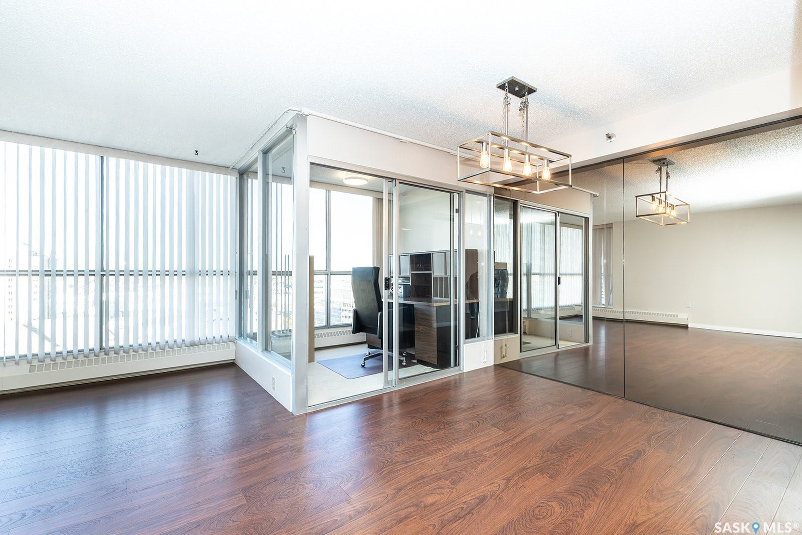 Laminate flooring, full-height windows with vertical blinds, glass-enclosed office space that can be removed if desired