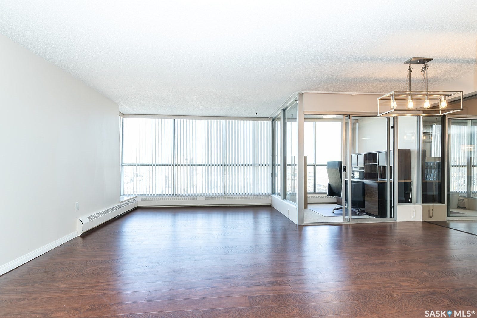 Laminate flooring, full-height windows with vertical blinds, glass-enclosed office space that can be removed if desired