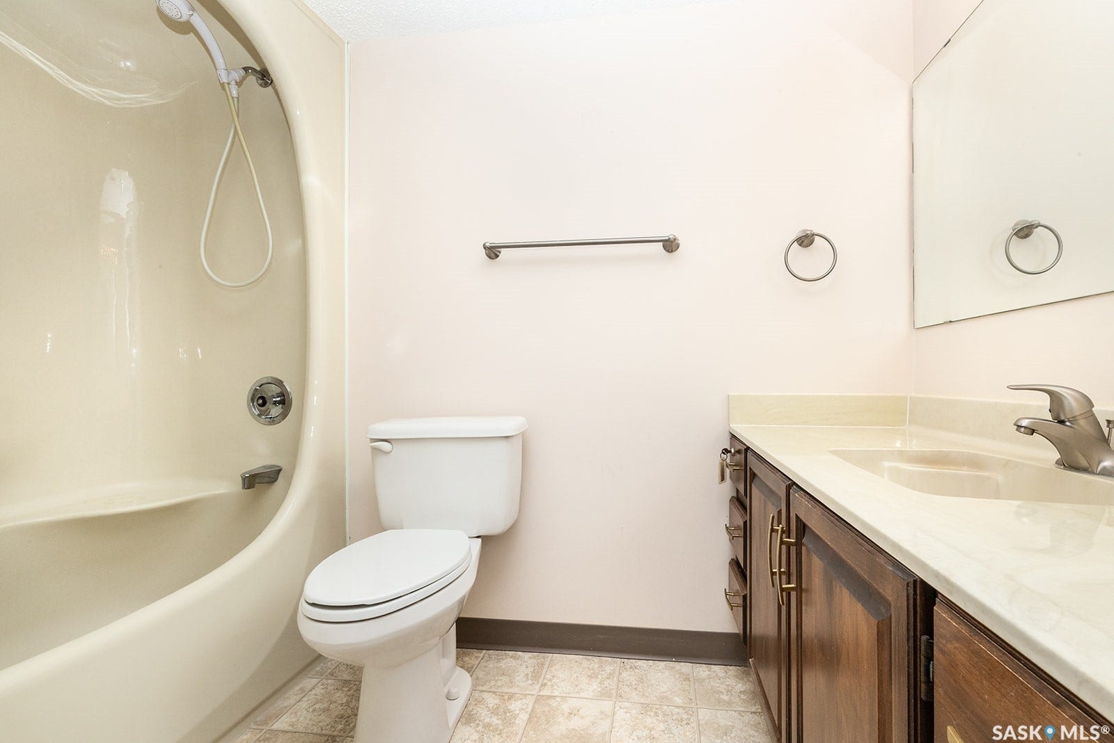 4 piece bath featuring bathtub and shower combination, white toilet, wood-finish vanity with ample storage, light-toned countertop with integrated sink, and wall-mounted mirror
