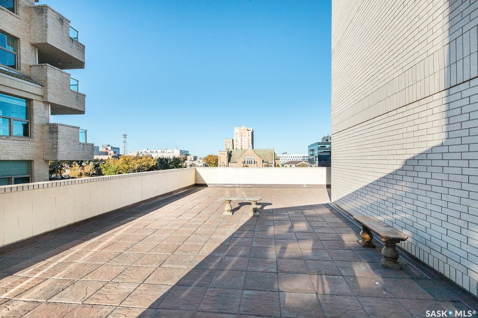 Expansive outdoor terrace with tiled flooring and a protective low wall