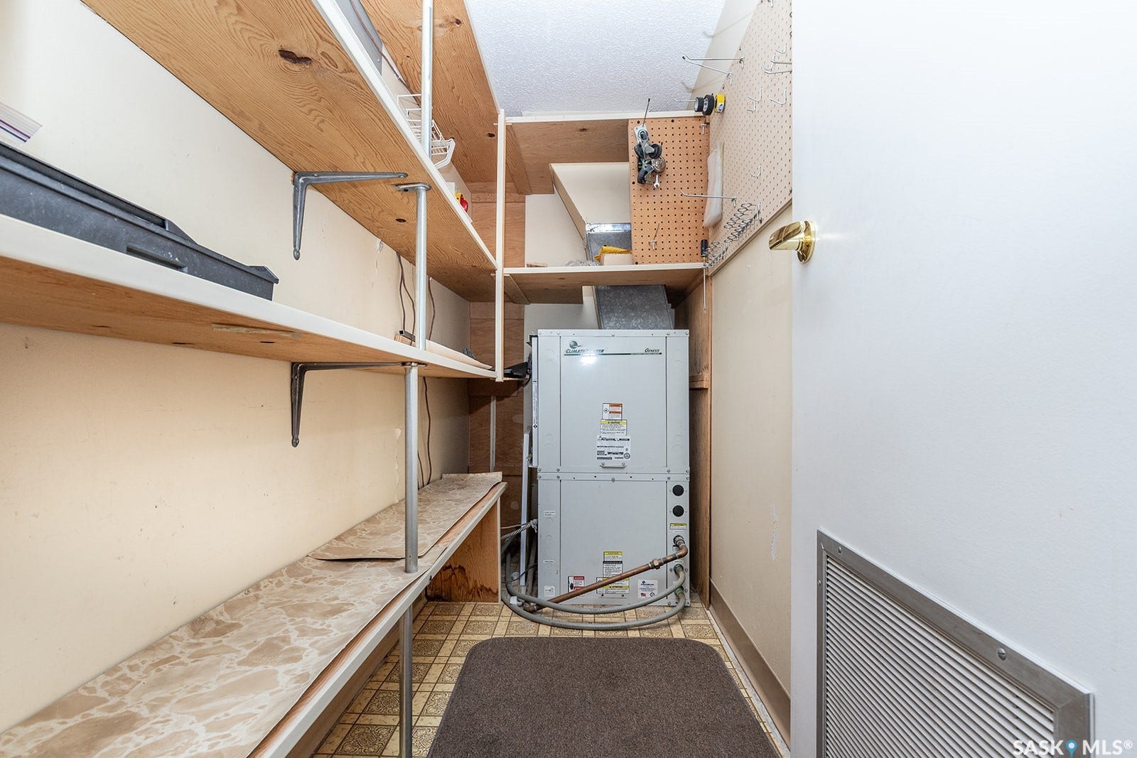 Utility area with built-in shelving, pegboard storage, and central air conditioning