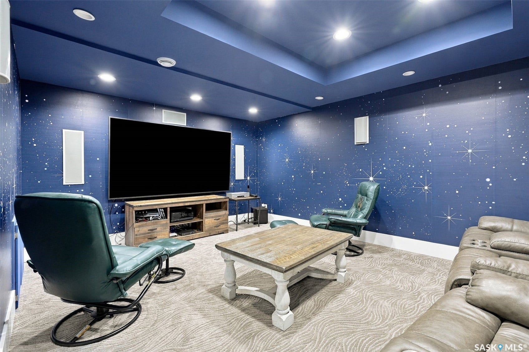 Entertainment room featuring a built-in television, recessed lighting, and wall-mounted speakers