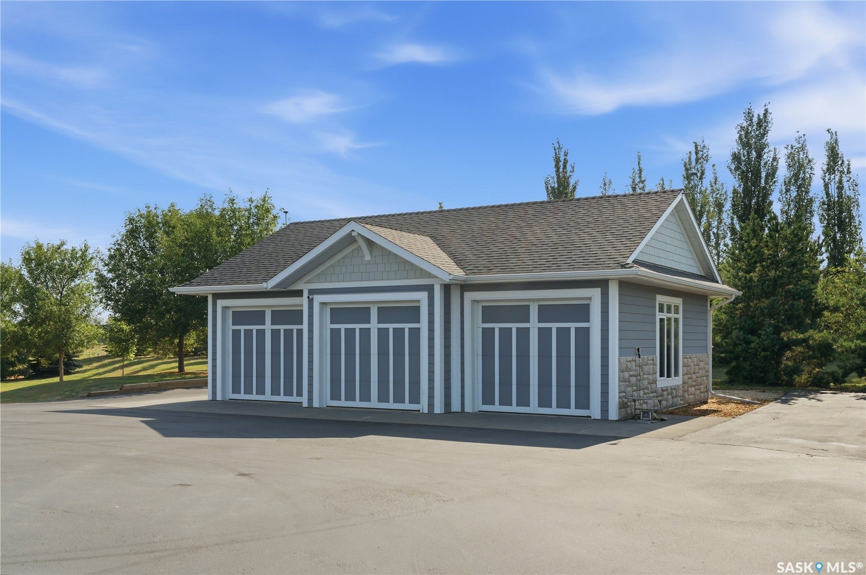 Three-car garage with shaker siding and stone veneer accents