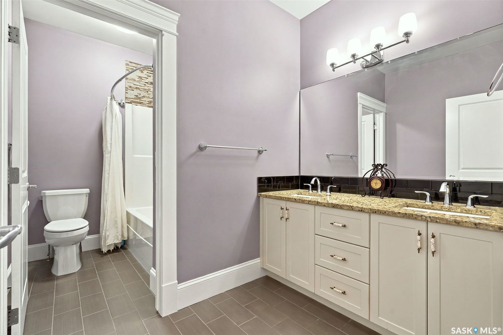 Double vanity with granite-style countertop, undermount sinks, and chrome fixtures