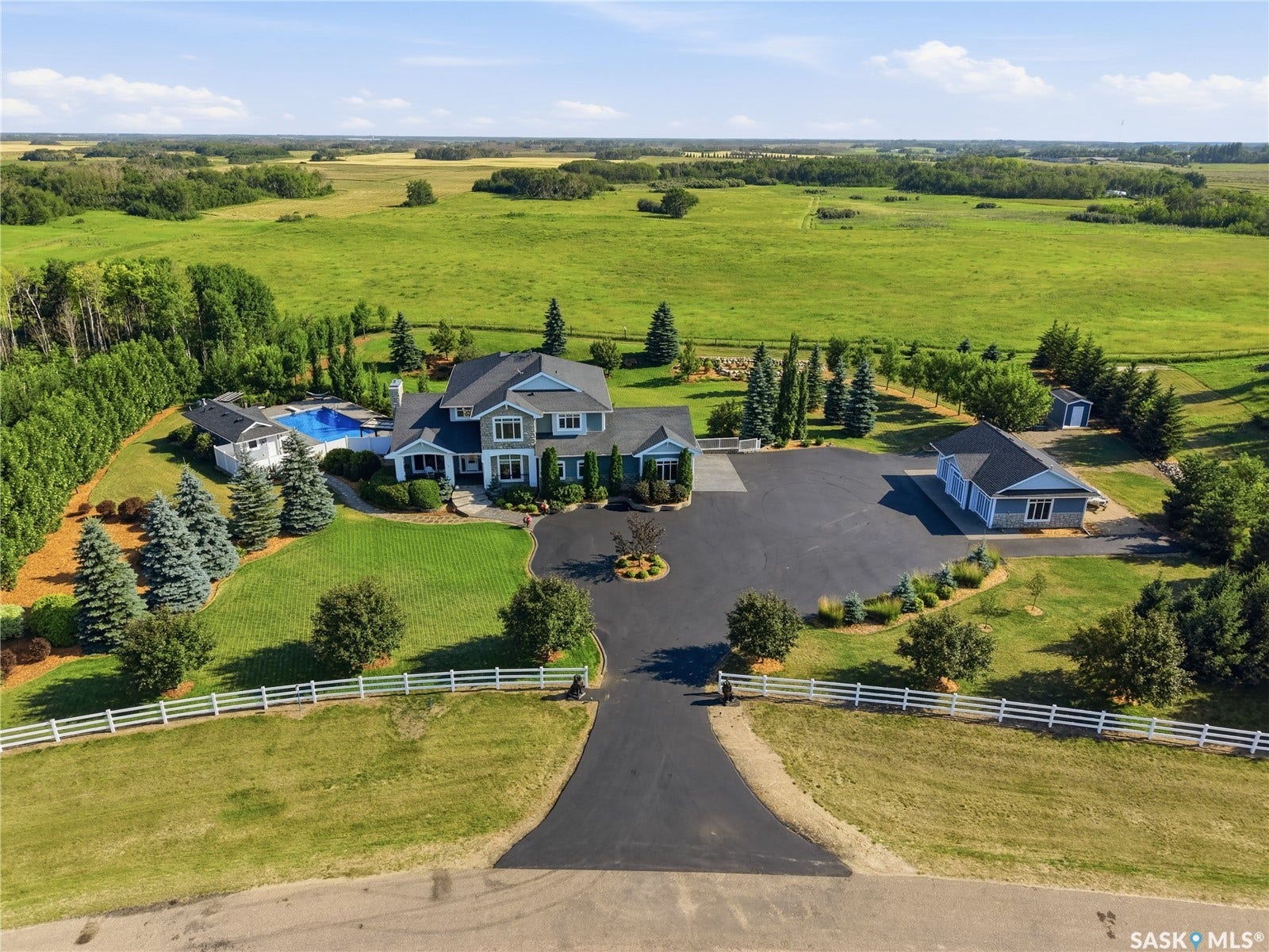 Extensive paved driveway leading to a multi-level residence with an attached garage