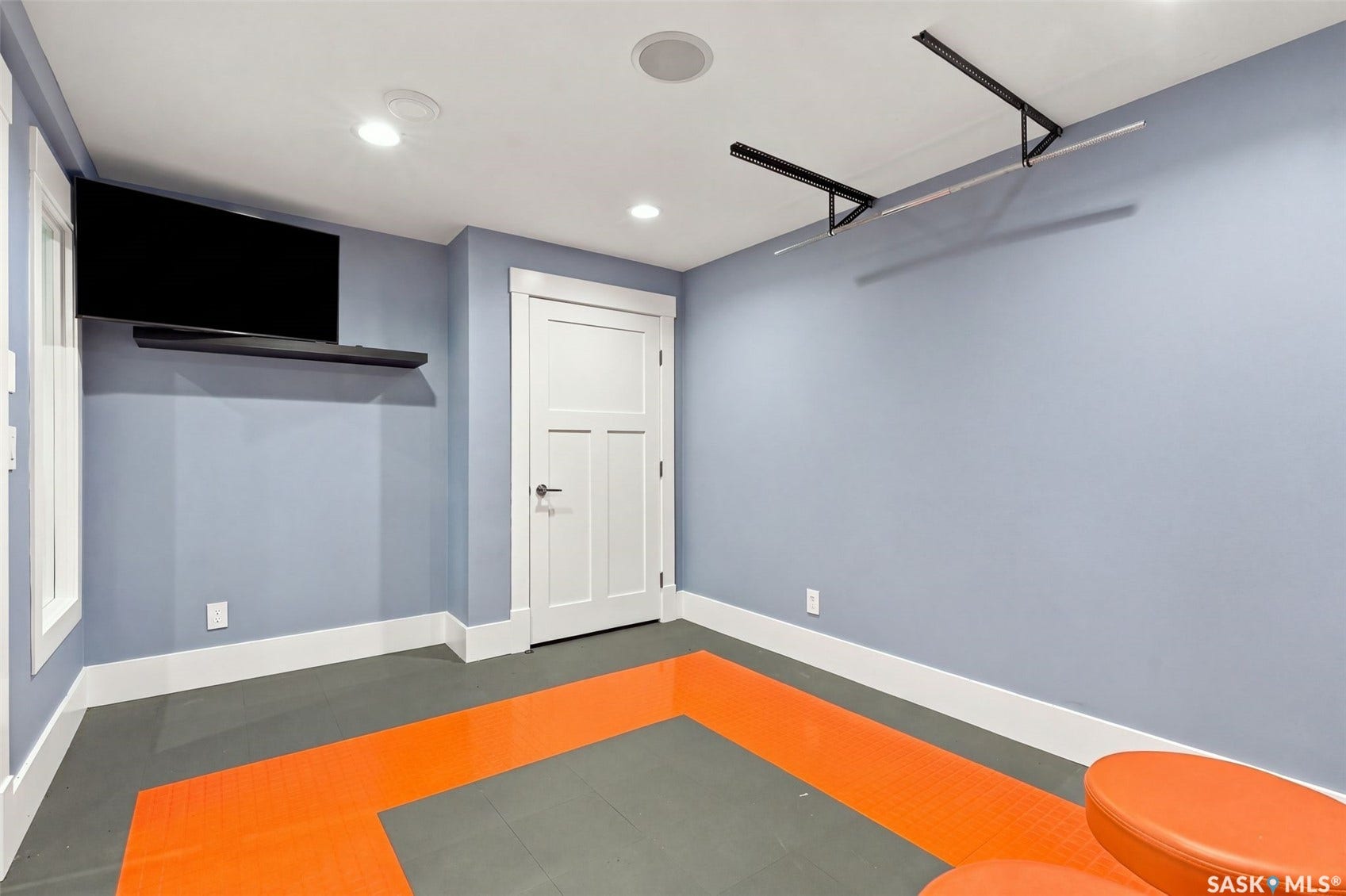 Recessed lighting, ceiling-mounted light fixtures, built-in wall shelf, flush paneled door, and multi-toned flooring