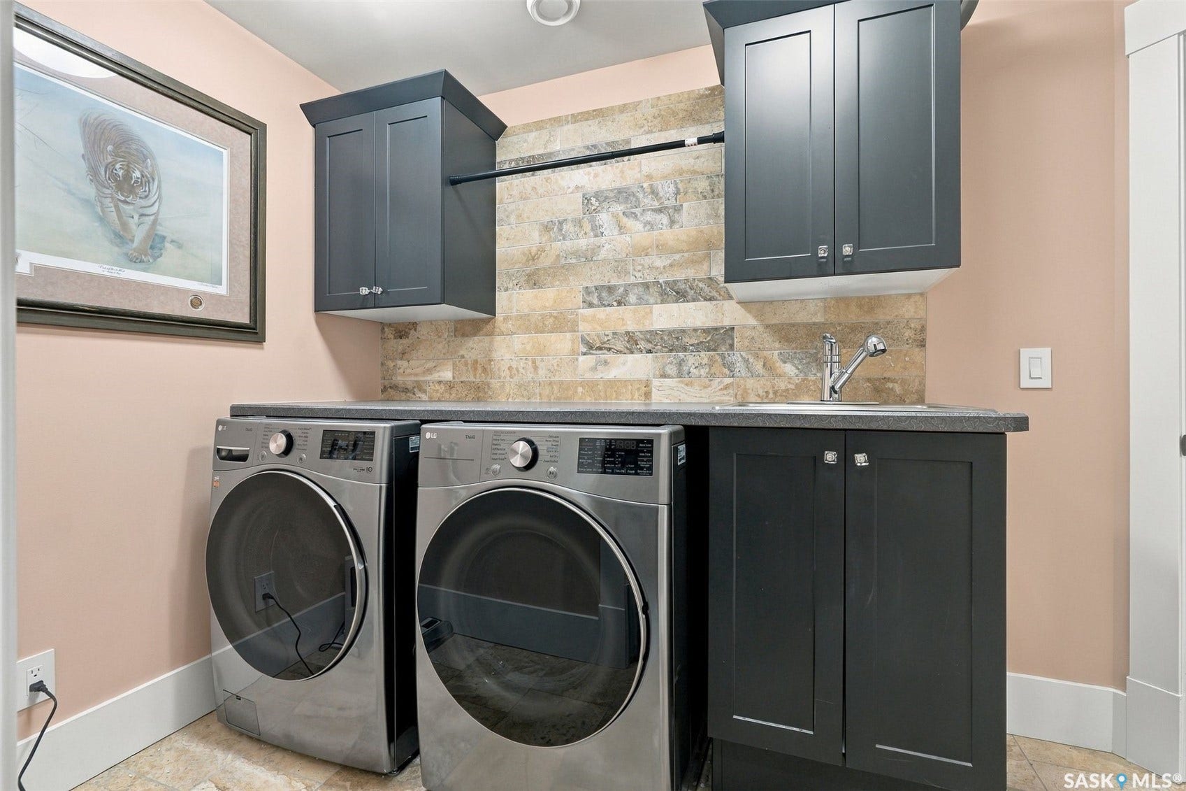 Built-in cabinetry, upper storage cabinets, sink, stone-finish countertop, and tile backsplash