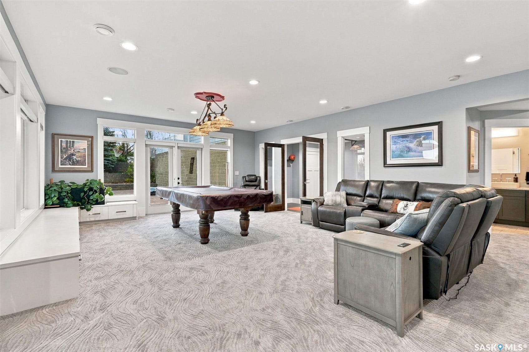 Recessed lighting, light gray walls, white trim, glass panel doors, and integrated built-in storage