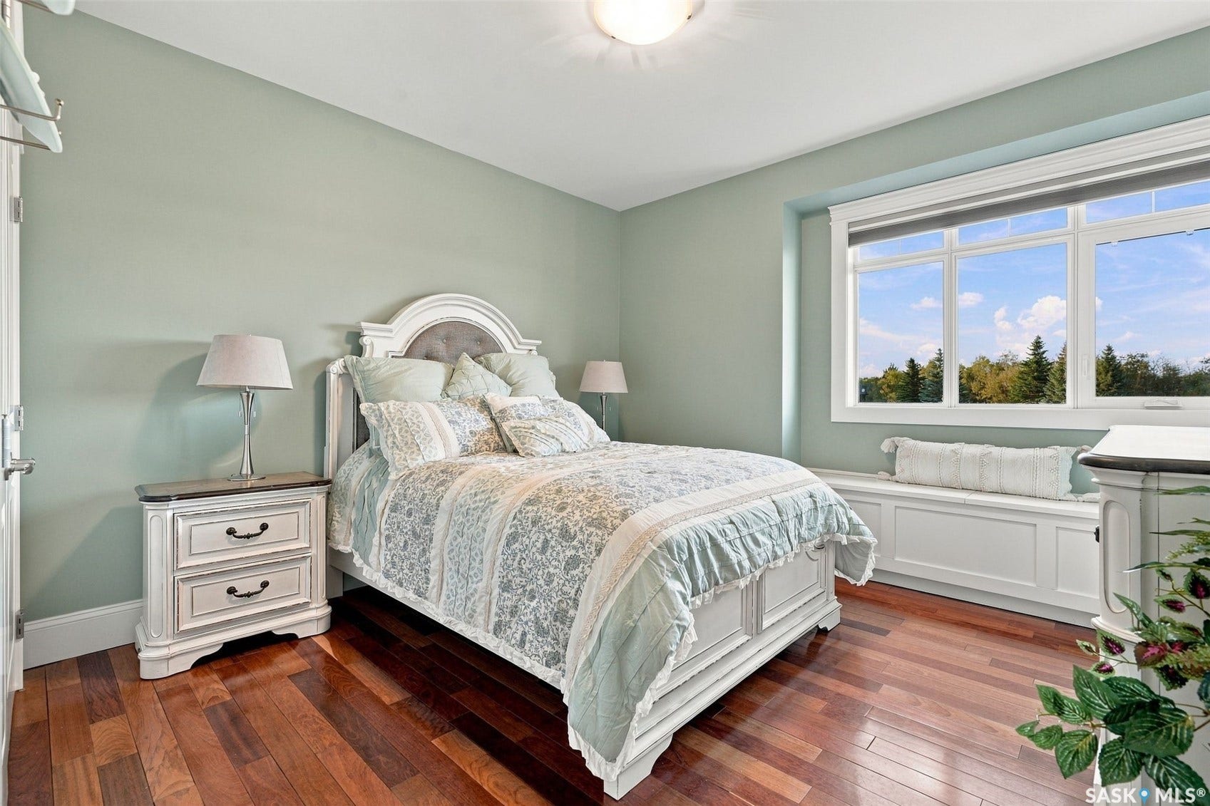 Hardwood flooring, expansive window, built-in window seat, ceiling-mounted light fixture, and light-toned wall paint