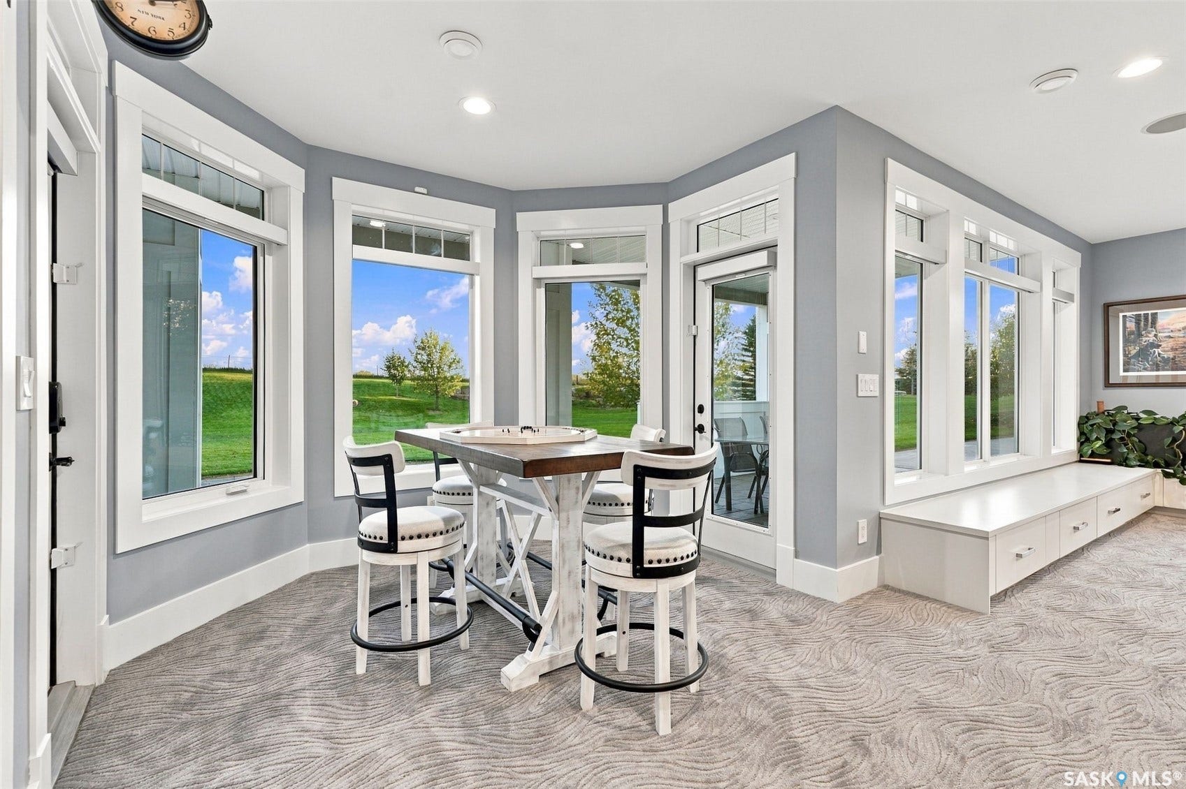 Bay of windows, built-in storage bench, and glass-paneled exterior door