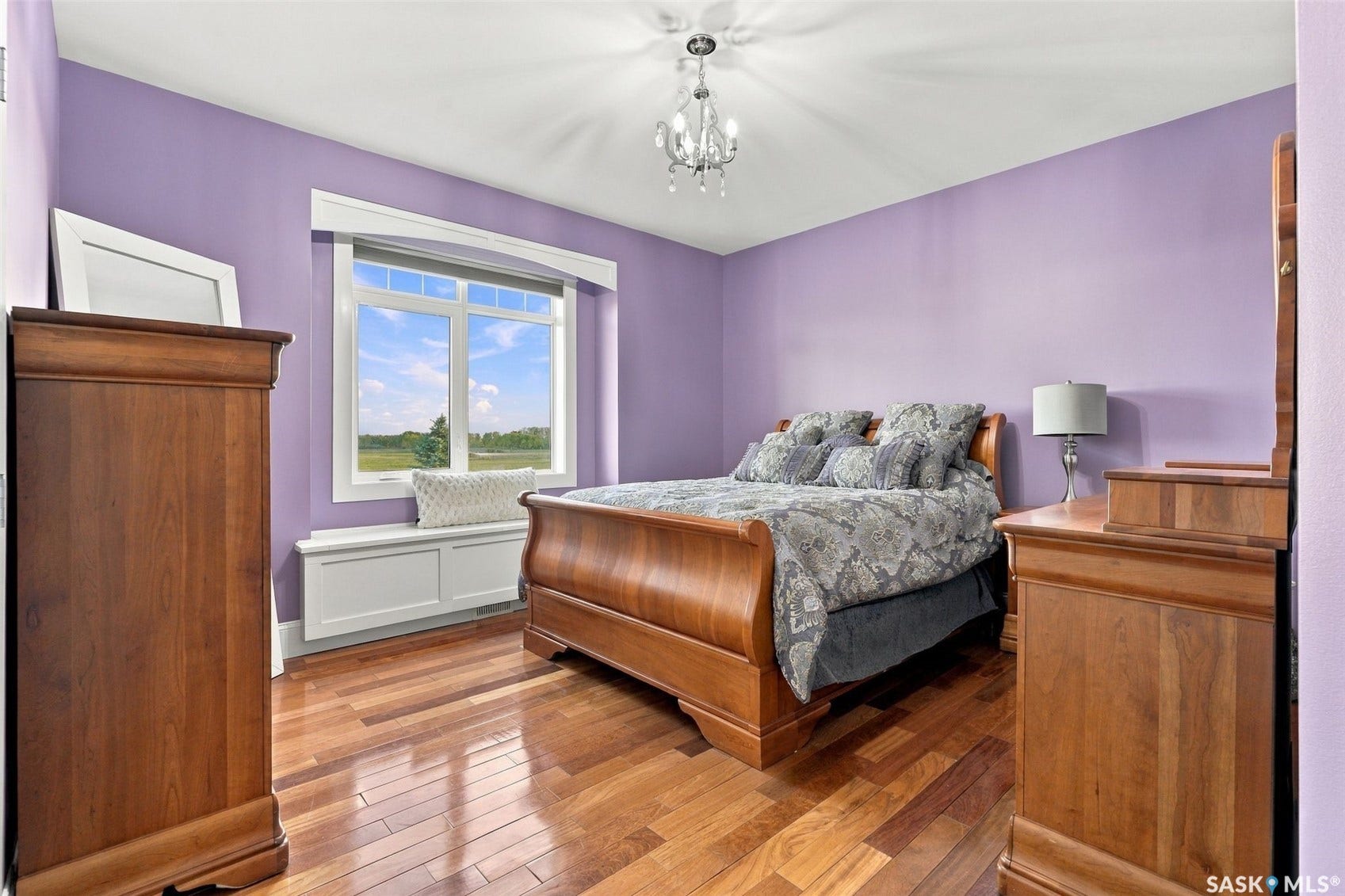 Hardwood flooring, chandelier lighting, large window with built-in window seat, and crown molding