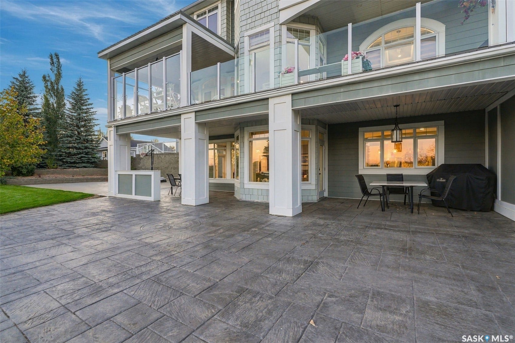 Stamped concrete patio with a covered outdoor area, supported by substantial white columns