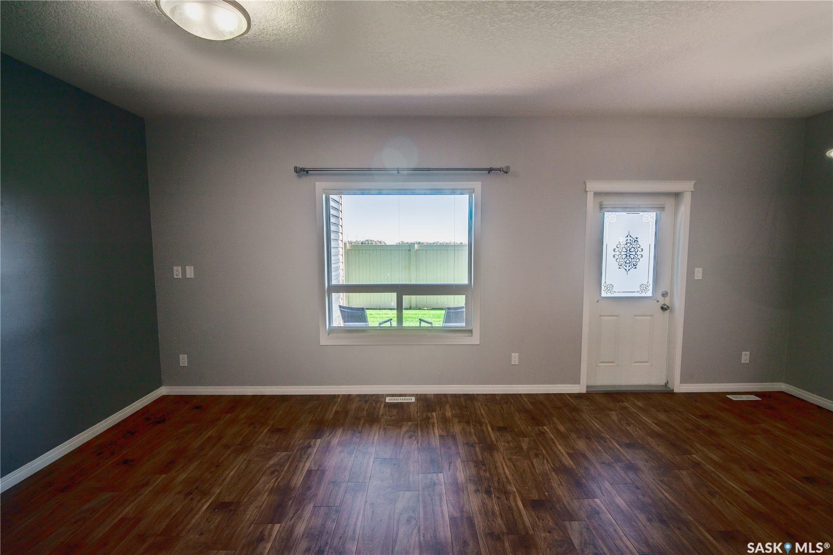 Wood-finish flooring, white trim, and a combination of light and dark wall finishes