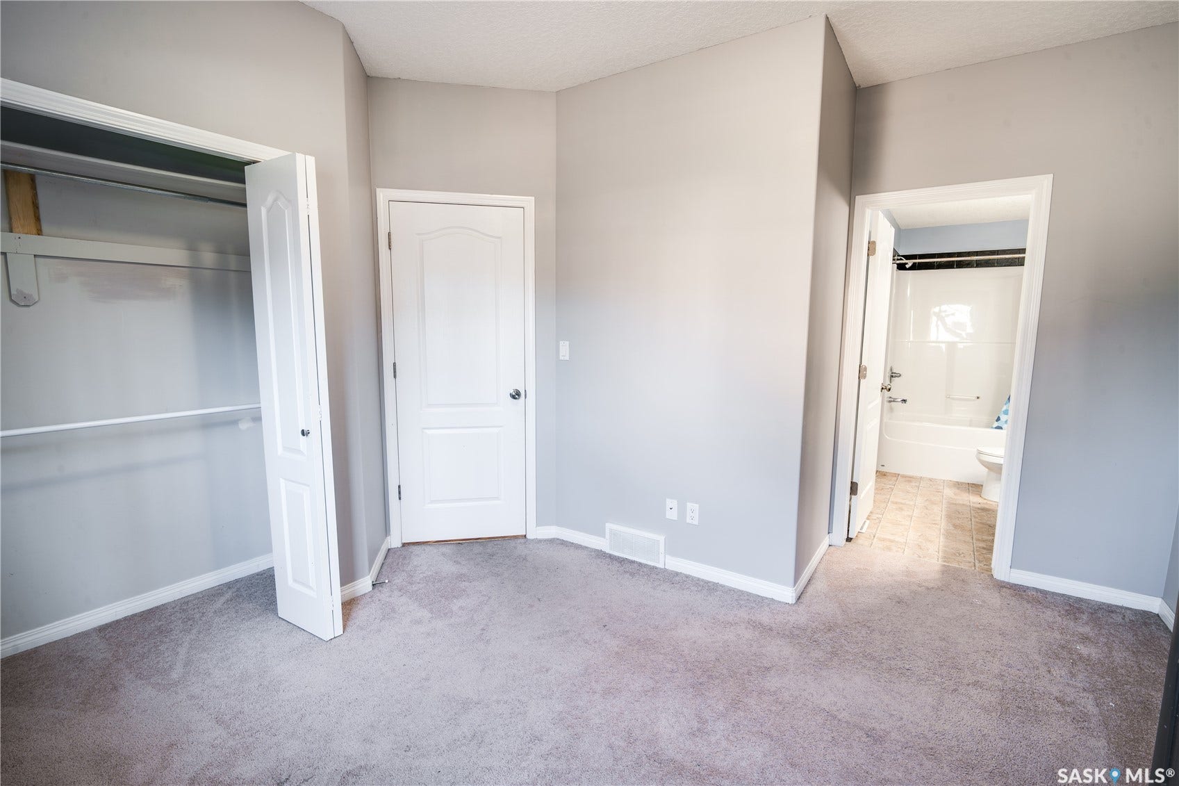 Plush carpet flooring, neutral painted walls, white trim, and a built-in closet with bi-fold doors