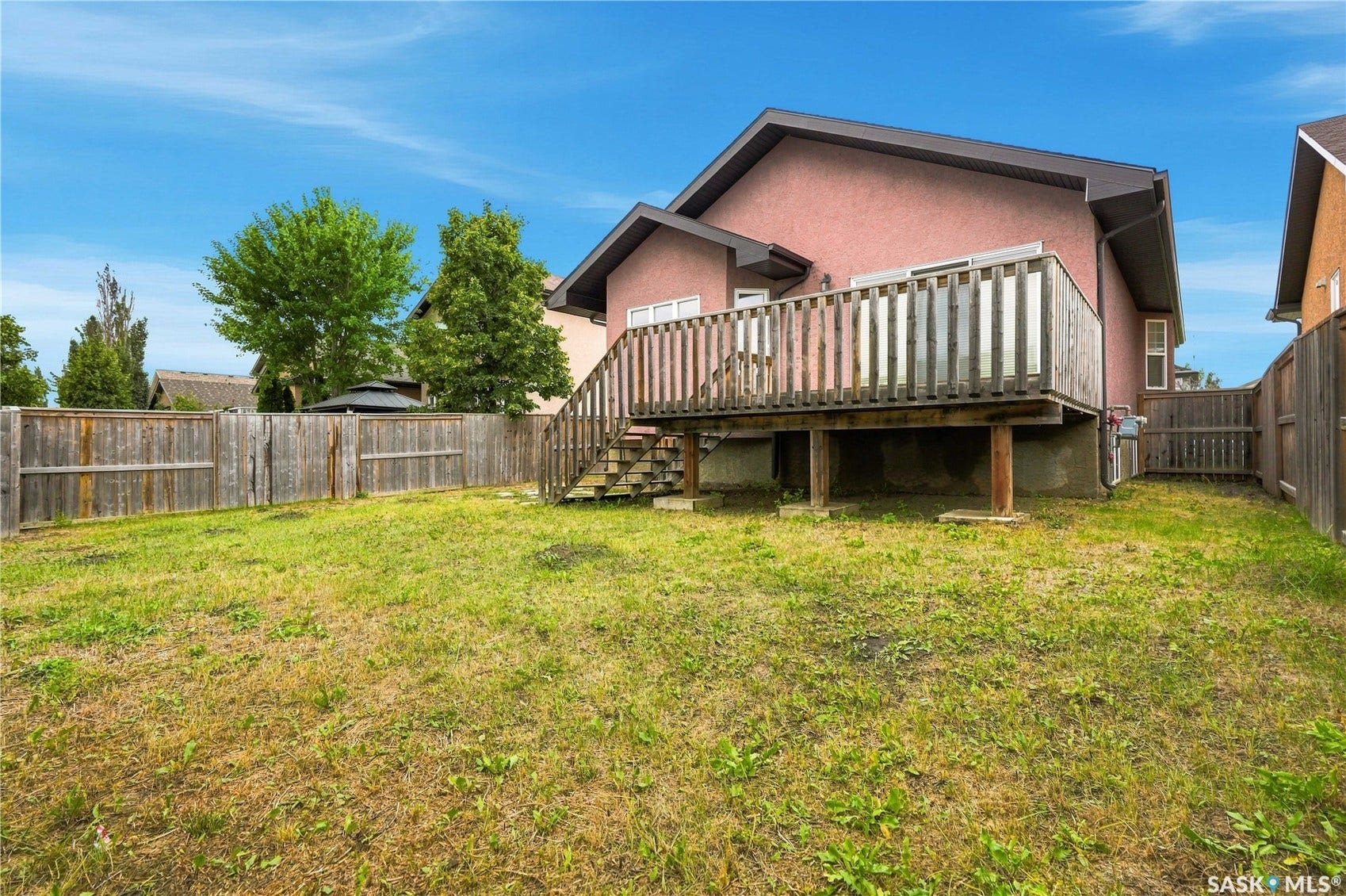Raised wood deck with privacy railing, stairs, and sliding door access