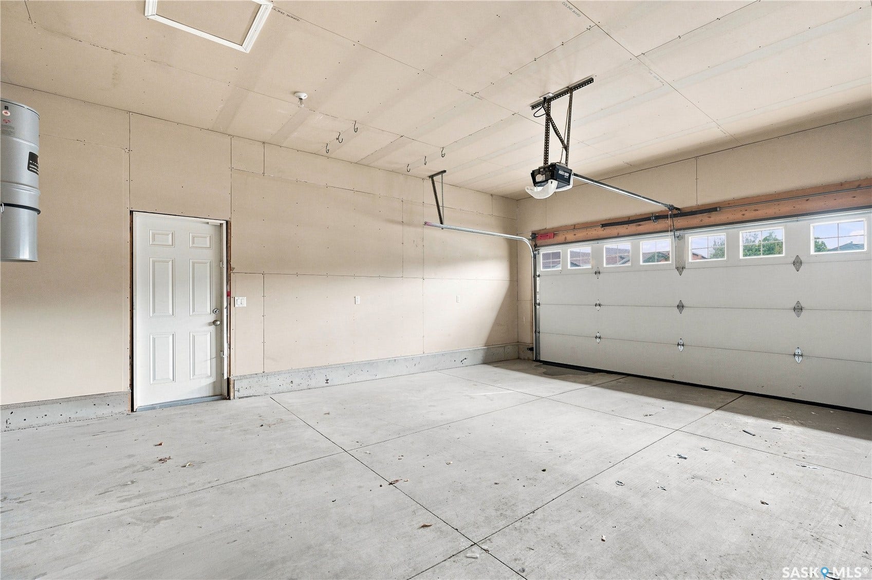 Spacious garage with an overhead door, multiple upper windows, and a built-in central vacuum system