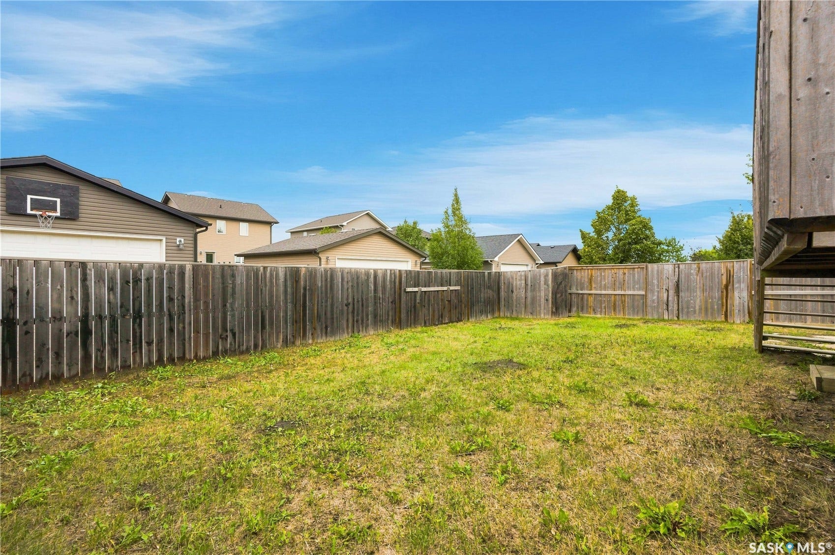 Expansive grassy yard with a full perimeter wood fence