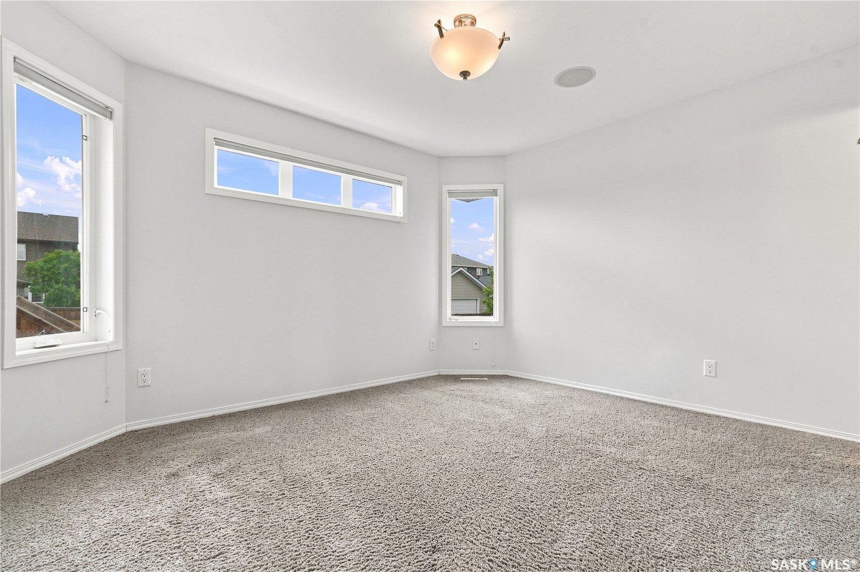 Recessed ceiling speaker, flush mount ceiling light fixture, multiple windows, and carpet flooring