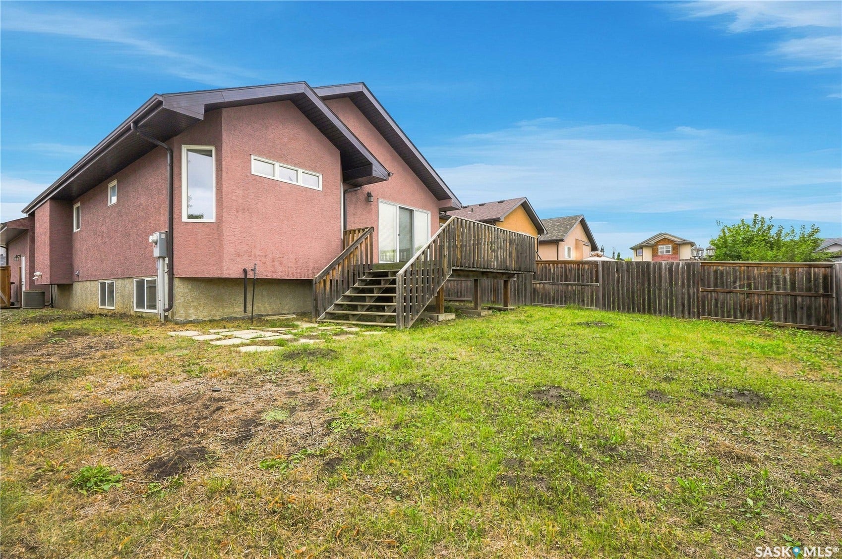 Stucco exterior with a raised deck and wood privacy fence