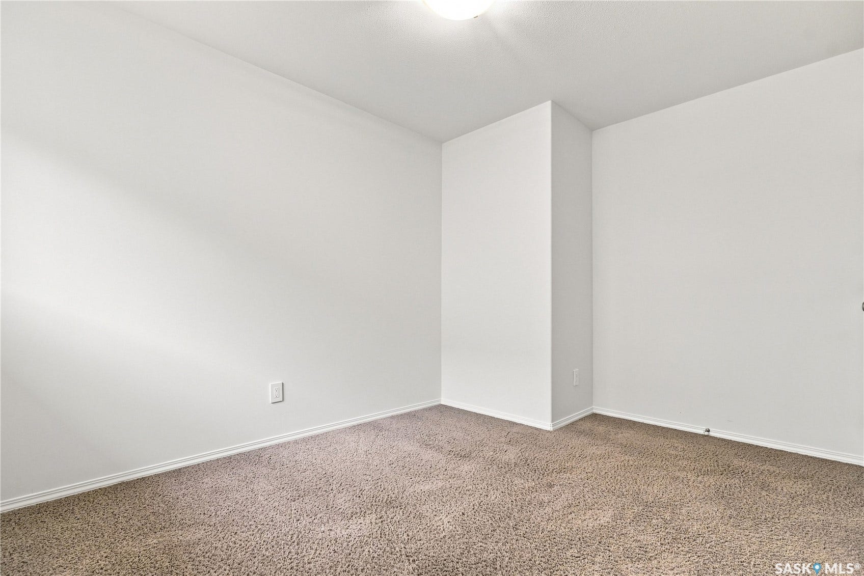 Neutral wall color with carpeted flooring and white trim