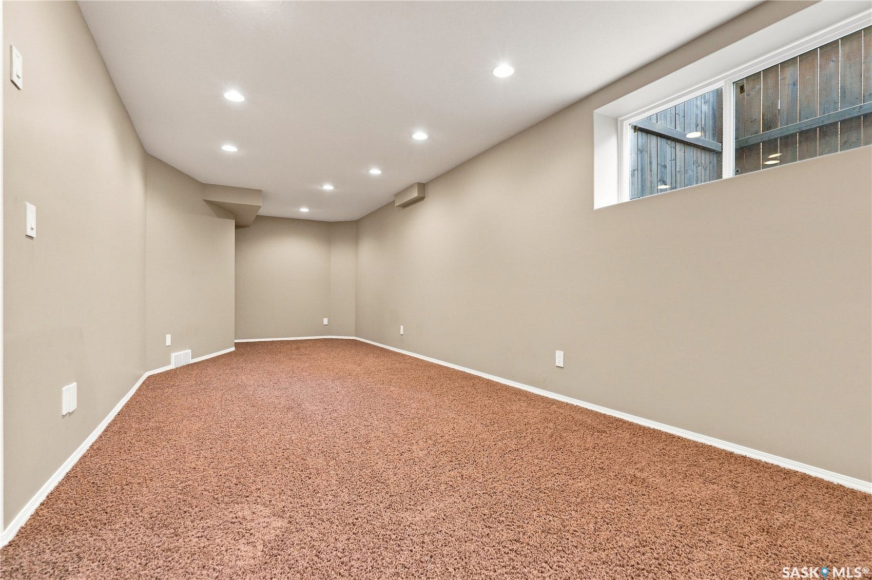 Expansive room featuring recessed lighting, a neutral paint palette, and a window