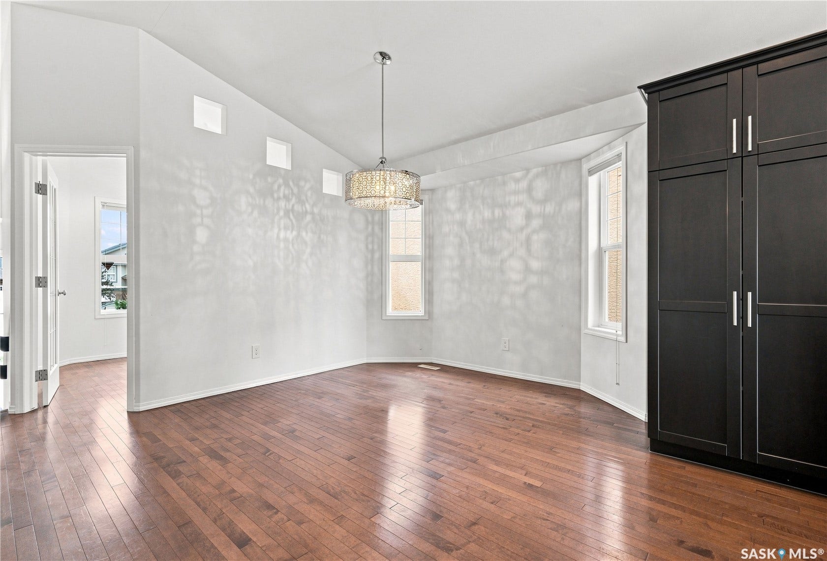 Hardwood flooring throughout, with a crystal chandelier and black built-in cabinetry