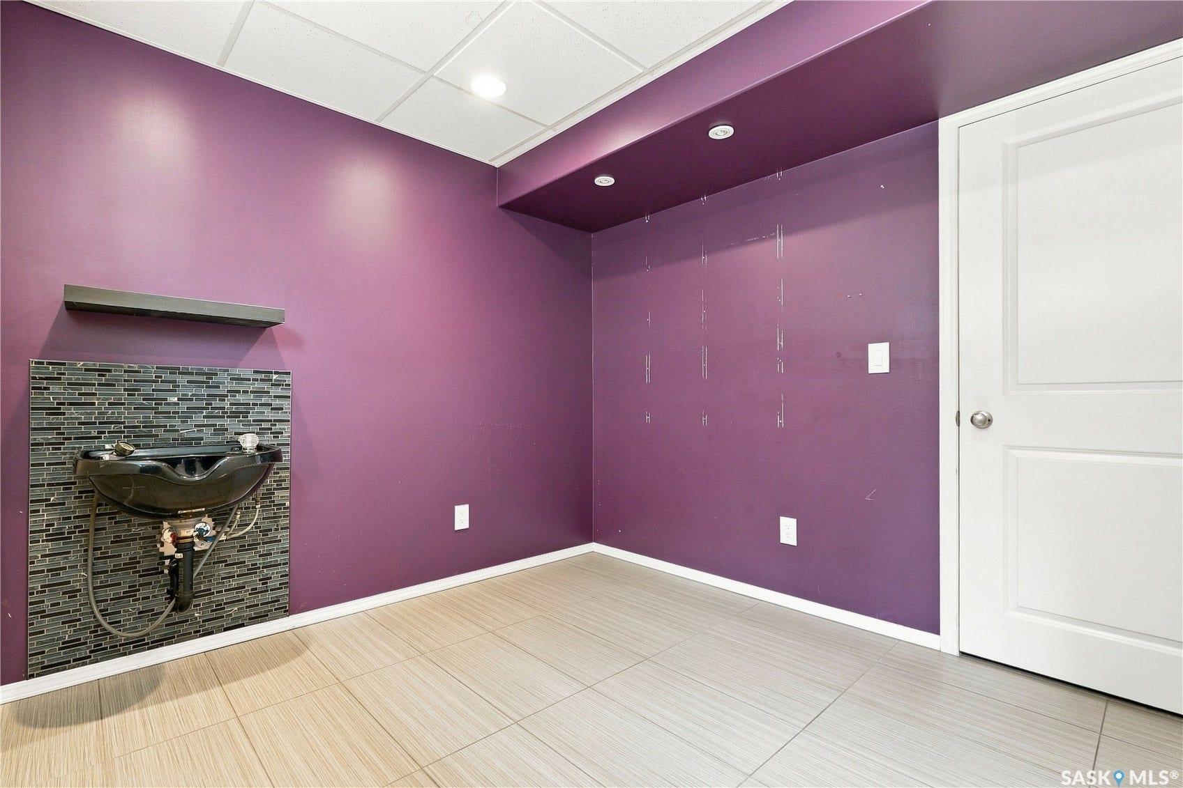Recessed lighting, drop ceiling, tile flooring, built-in shampoo bowl, and accent tile backsplash