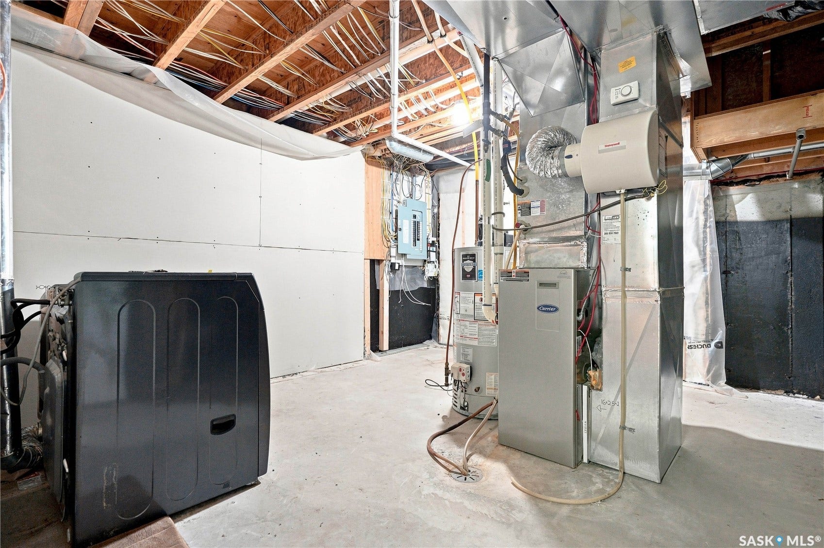 Exposed ceiling joists, concrete flooring, and unfinished drywall sections