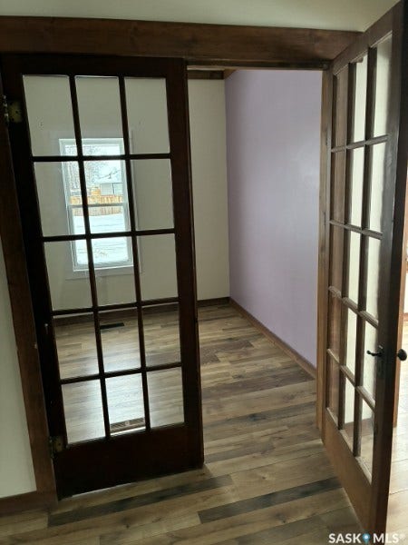 Wood-finish flooring throughout, complemented by French doors with divided lites and dark wood trim