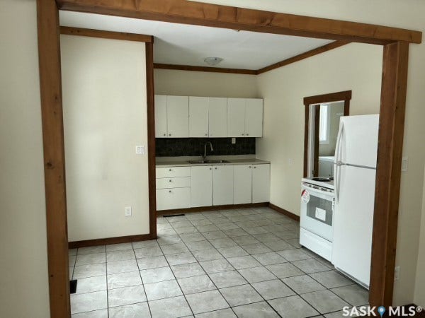 Kitchen featuring white cabinetry, tile flooring, white refrigerator, and white range