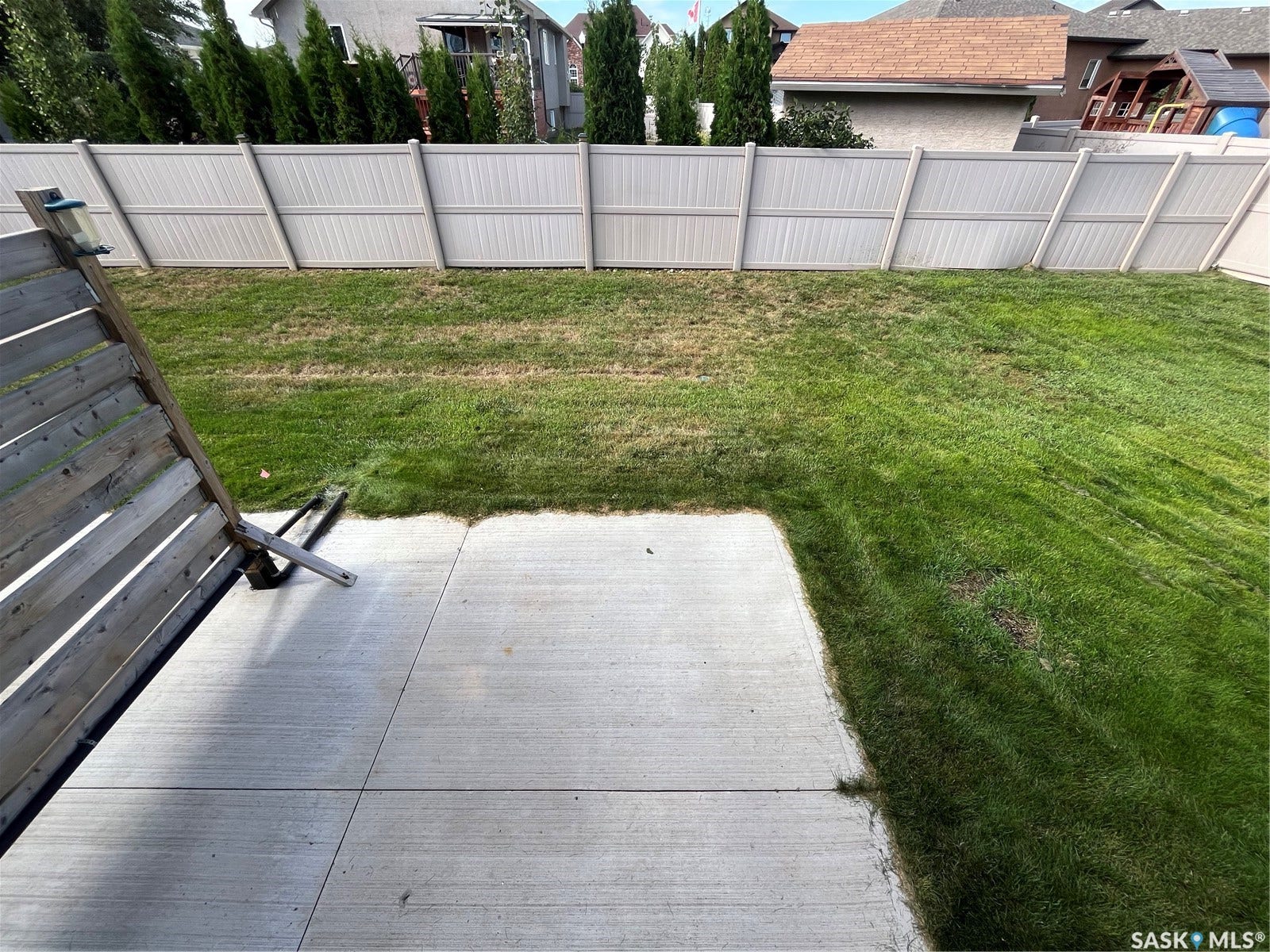 Expansive backyard featuring a concrete patio and a privacy fence