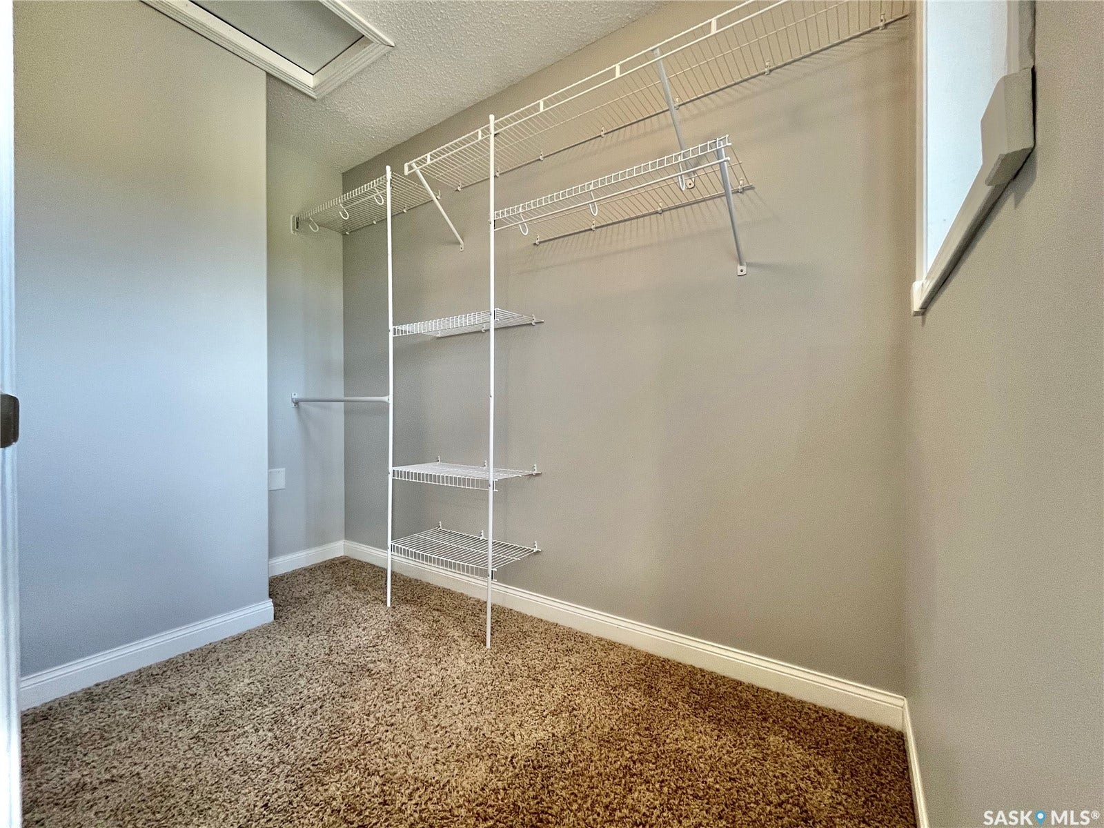 Built-in wire shelving system, neutral wall paint, and textured carpeting