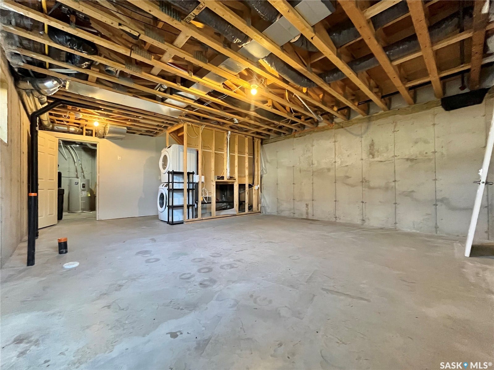 Unfinished basement with exposed ceiling joists and concrete flooring