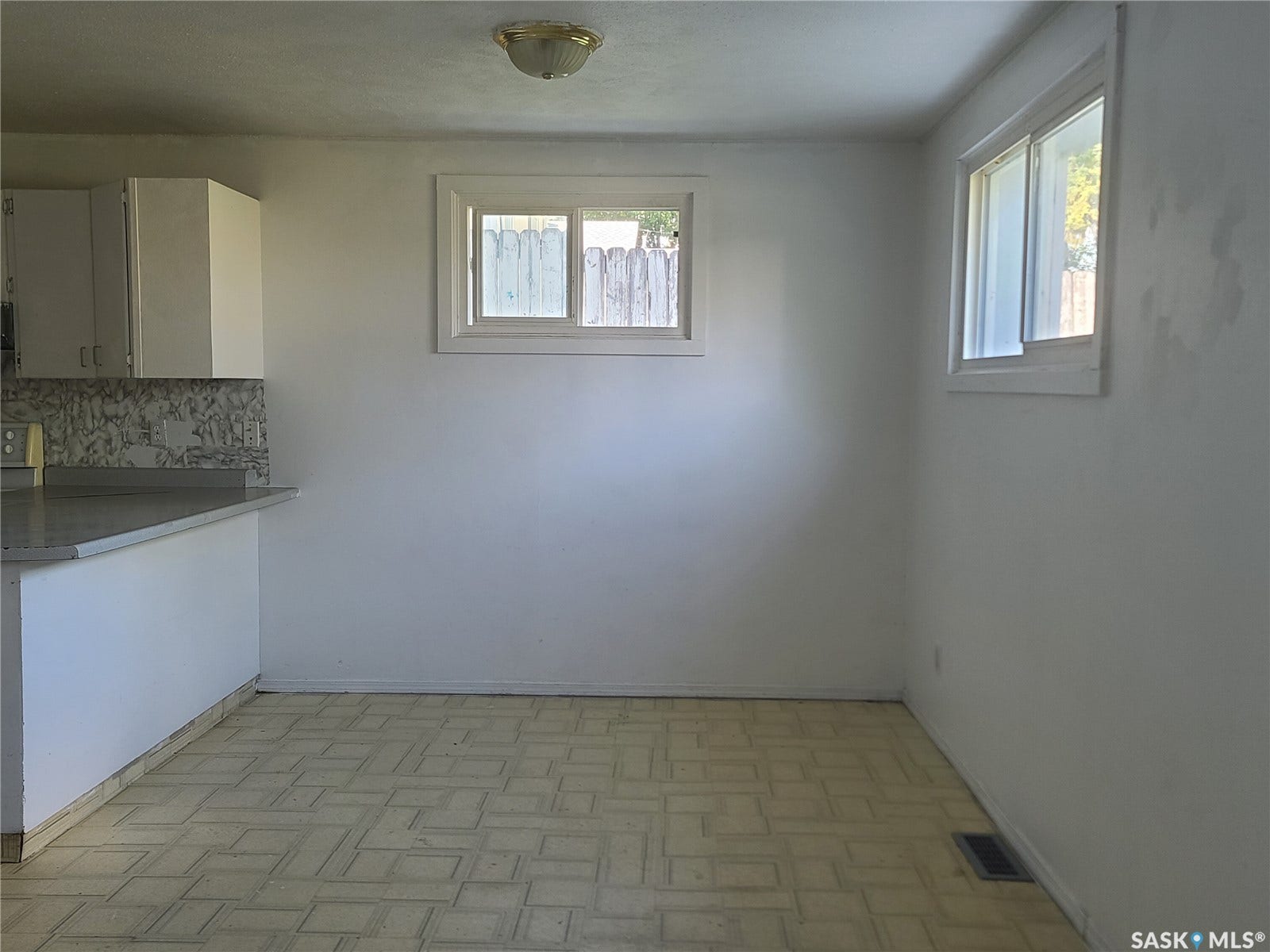 Built-in cabinetry with white flat-panel doors, light-toned countertop, and patterned backsplash