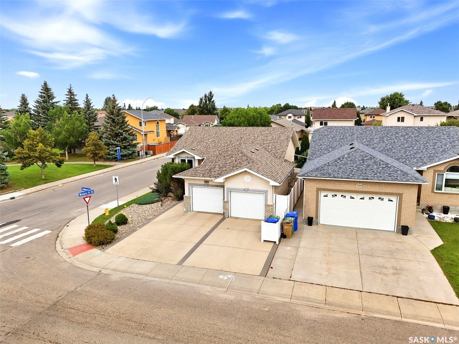 Two single-car garages with concrete driveways
