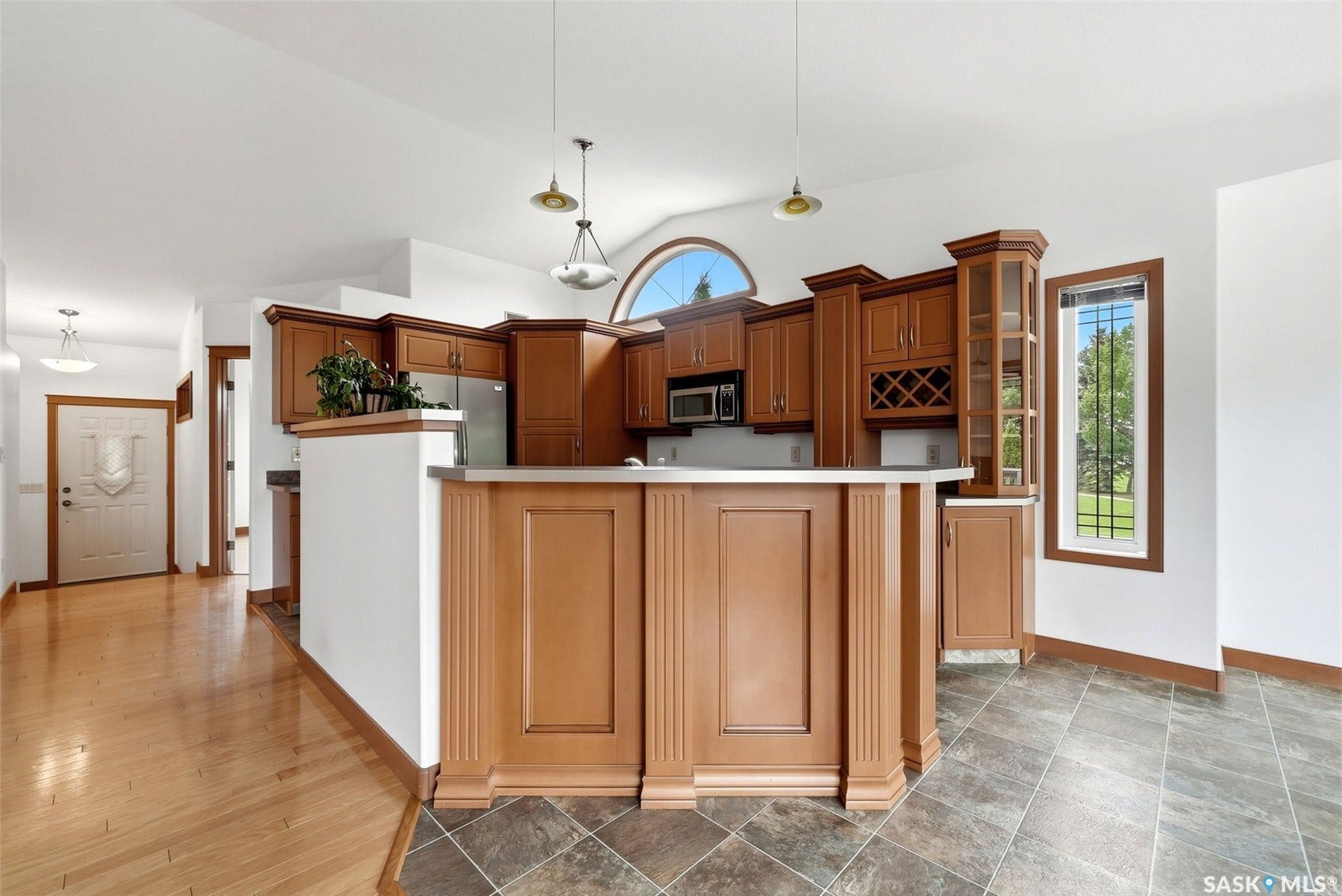 Kitchen area featuring wood cabinetry, stainless steel appliances, and a built-in wine rack