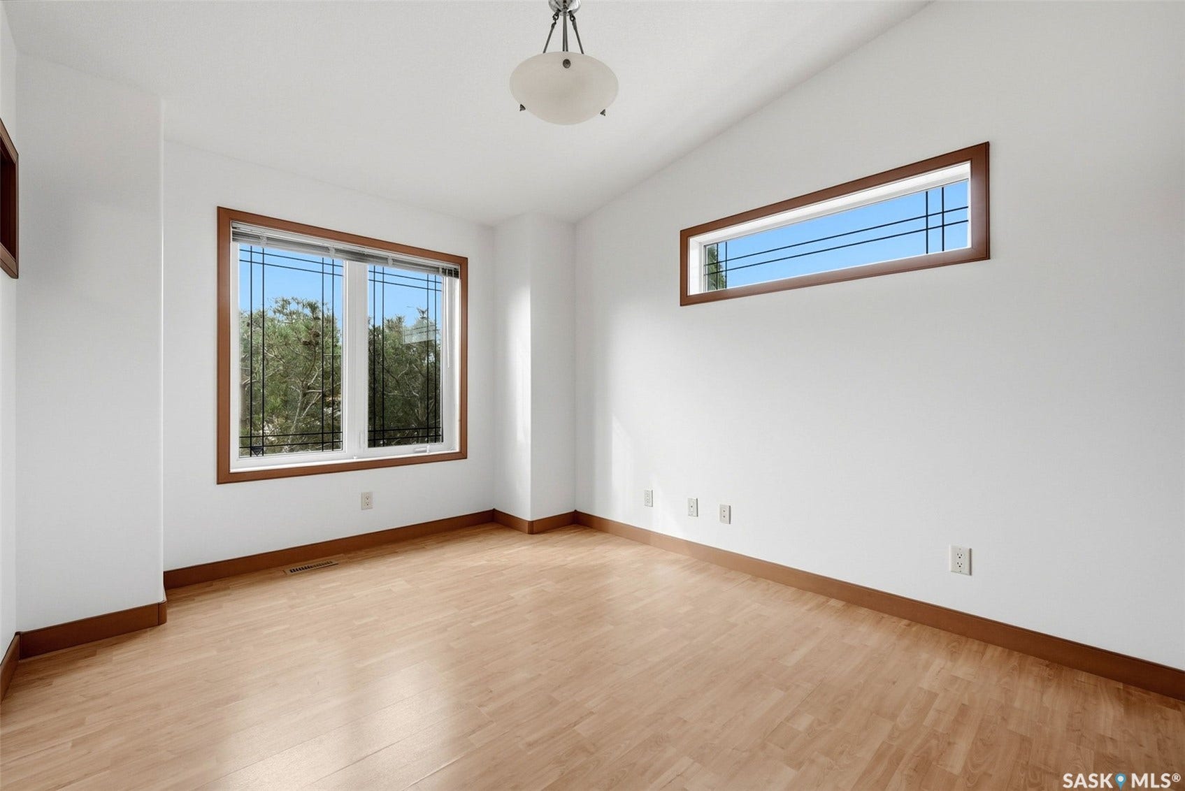 Light wood-finish flooring, white walls, and a semi-flush mount ceiling fixture