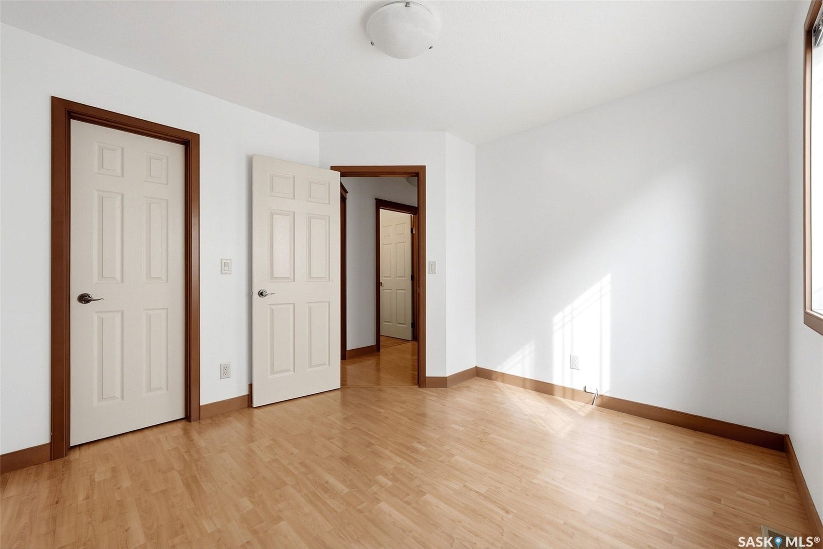 Wood-finish flooring with white walls and dark wood trim