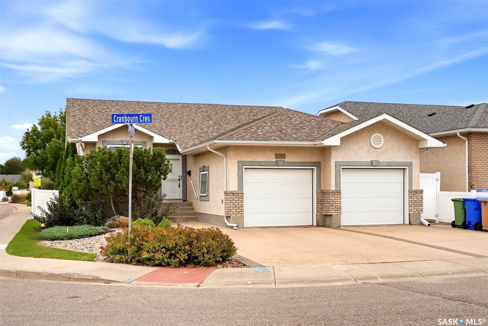 Stucco exterior with brick detailing, asphalt shingle roofing, and an attached two-car garage