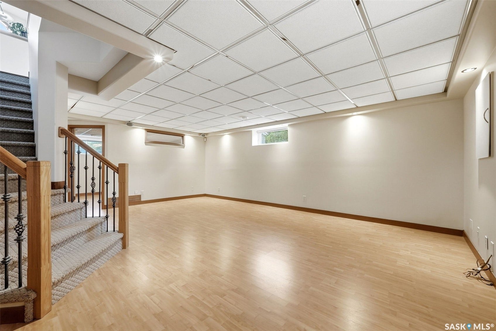 Spacious room with wood-finish flooring, recessed lighting, and a drop ceiling