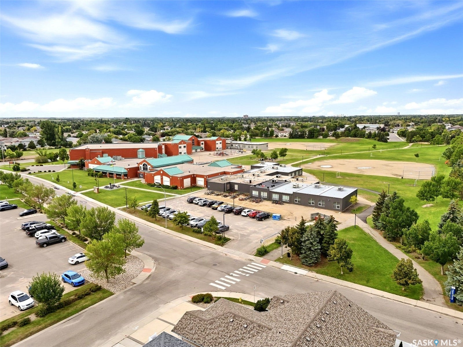 Expansive community setting featuring multiple buildings, paved roads, and green spaces