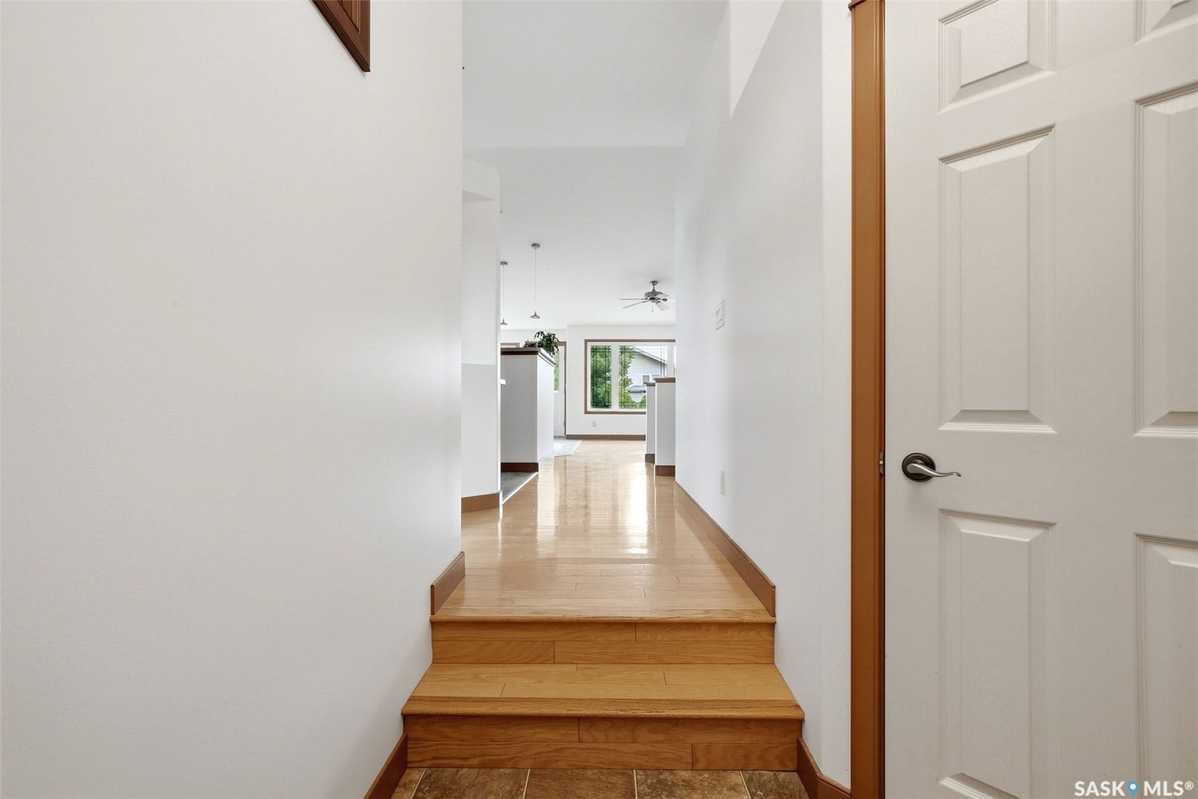 Light wood-finish flooring with a multi-paneled door