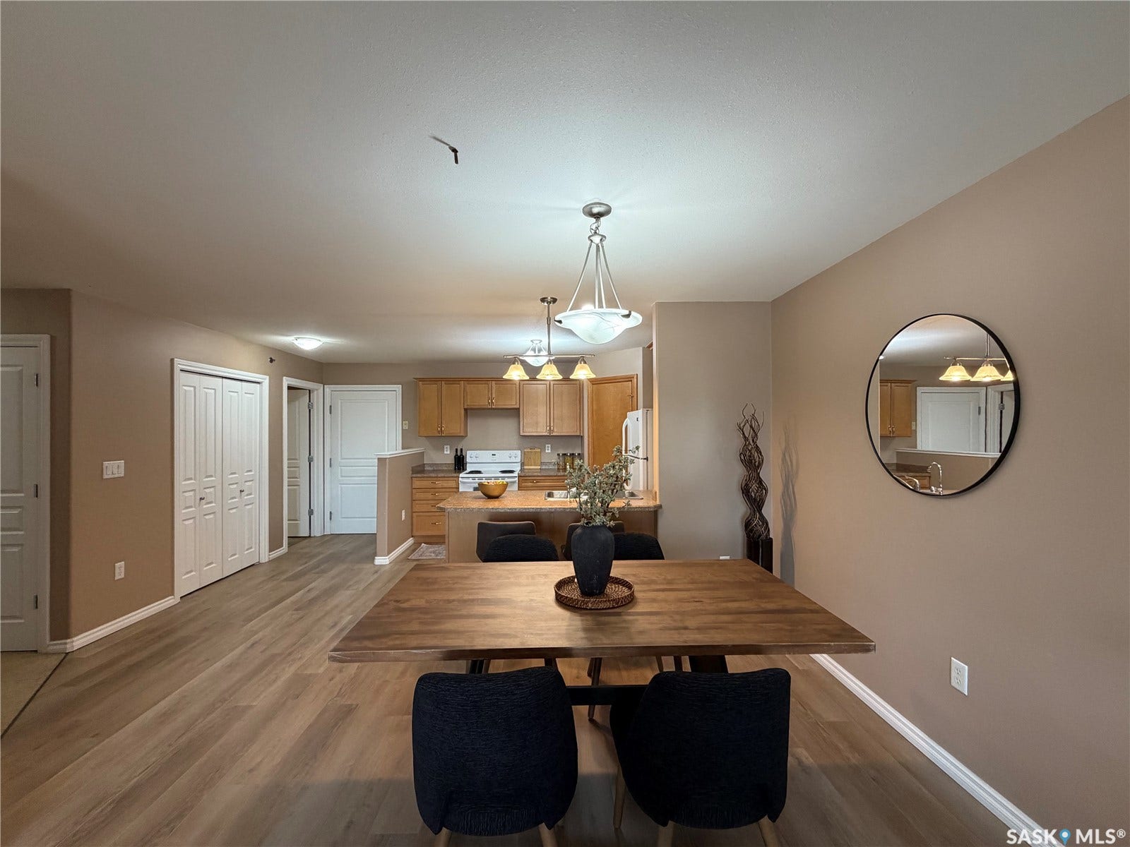 Wood-finish flooring throughout, with a dining area featuring an overhead chandelier