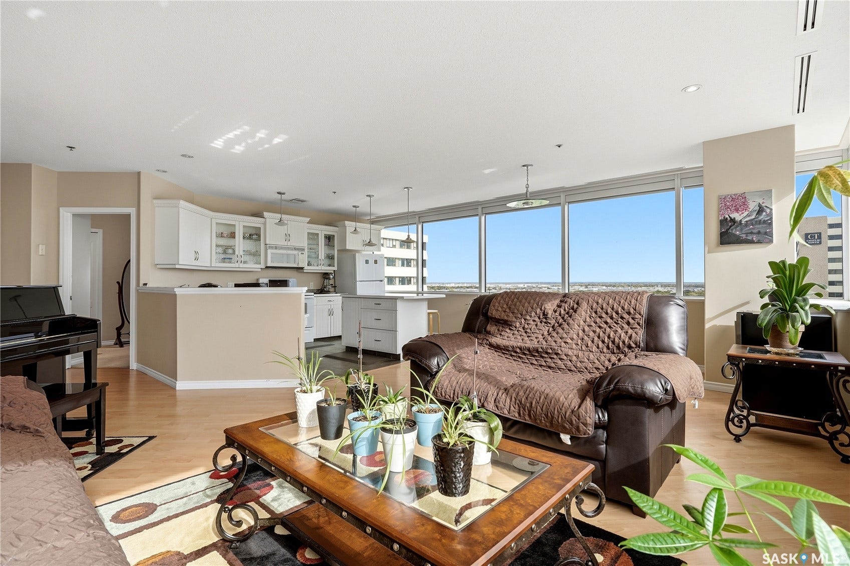 1914 Hamilton Street, #1007, Regina SK S4P 3N6 Expansive windows, light wood-finish flooring, recessed lighting, and white cabinetry with glass-front accents