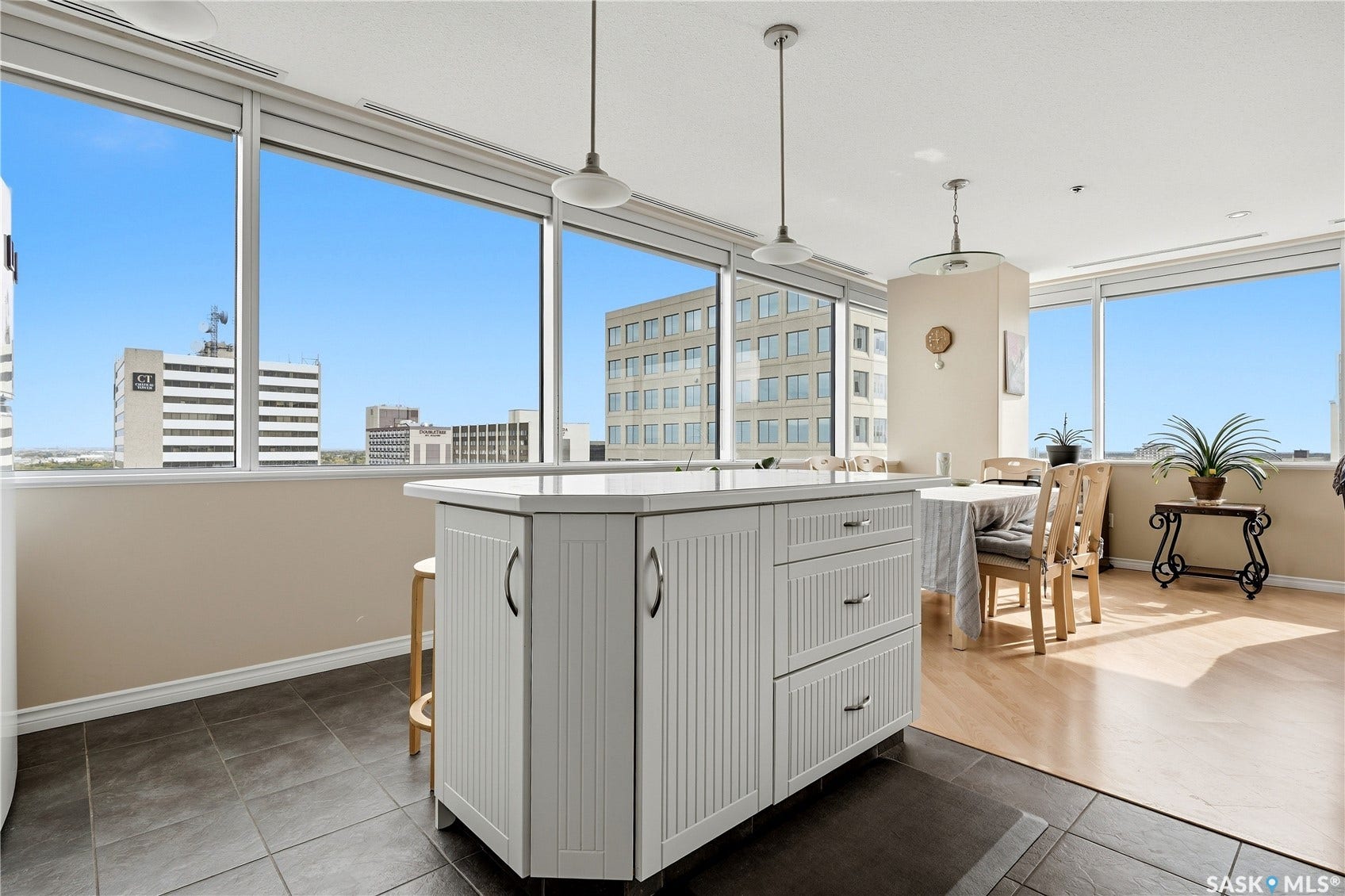 1914 Hamilton Street, #1007, Regina SK S4P 3N6 Floor-to-ceiling windows, white kitchen island with storage, pendant lighting, wood-finish flooring, and dark tile flooring