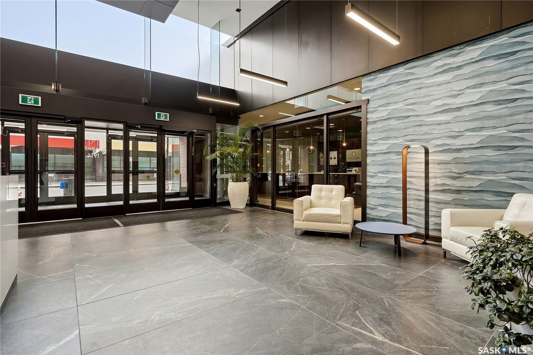 1914 Hamilton Street, #1007, Regina SK S4P 3N6 Expansive lobby featuring large format tile flooring, a distinctive textured accent wall, and a high ceiling with linear pendant lighting