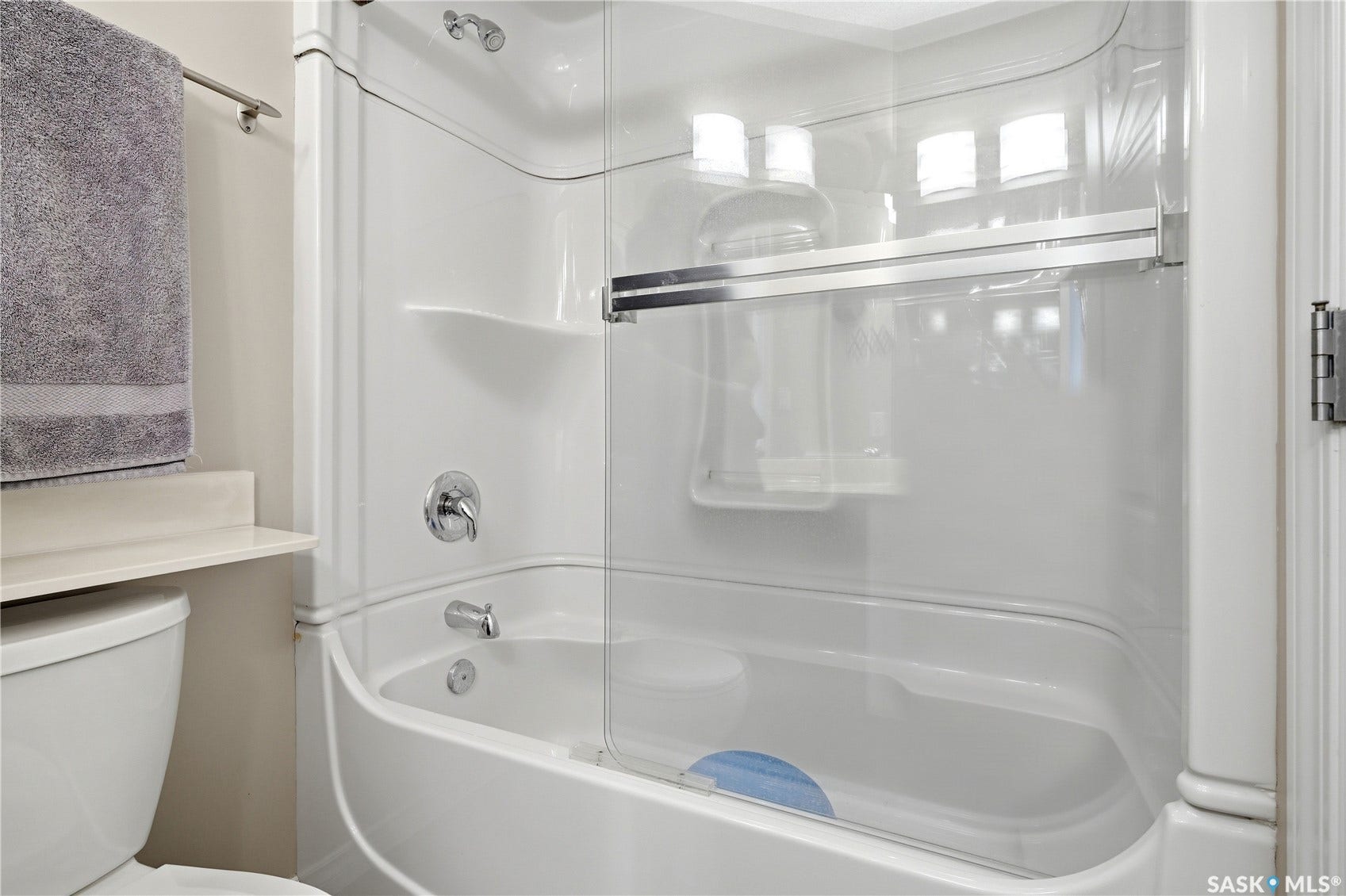1914 Hamilton Street, #1007, Regina SK S4P 3N6 White composite tub and shower combination with chrome fixtures and clear glass sliding doors